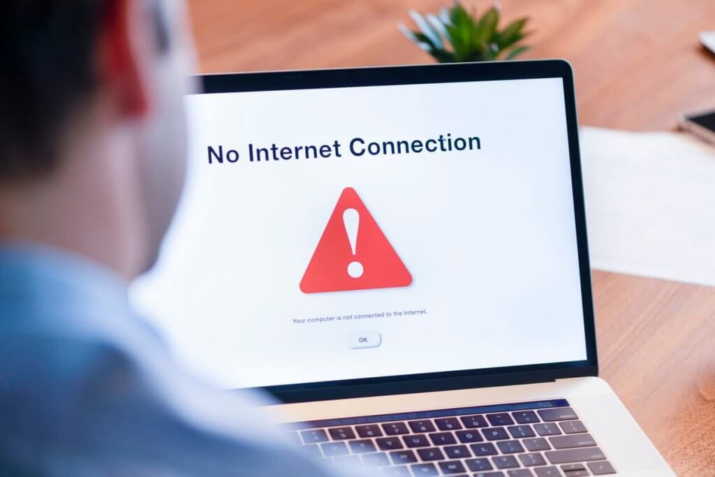 Man looking at a computer screen that has no internet connection, digital divide concept
